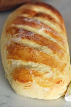 a piece of bread sitting on top of a counter next to a baguette