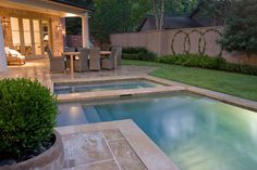 a backyard with a pool and patio furniture