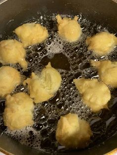 some dumplings are cooking in a pot on the stove top with boiling water around them