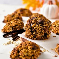 chocolate and oatmeal cookies are sitting on top of parchment paper with pumpkins in the background