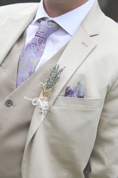 a man wearing a suit and tie with a boutonniere on his lapel