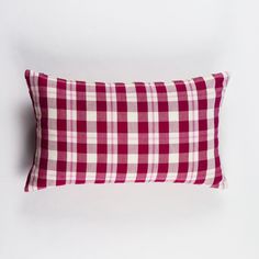 a red and white checkered pillow on a white background