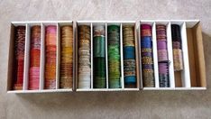 a box filled with different colored spools of thread