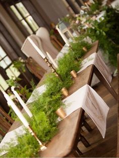 an image of a table set up with flowers and greenery on the table top