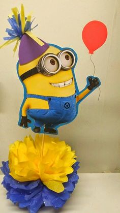 a yellow and blue birthday cake with a minion on top