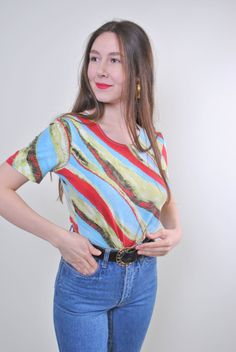 "Abstract print women holiday multicolor tshirt for festival, Size M Welcome to TARASCOMMON.ETSY.COM Unique clothing from the 20th century. Model tall - 170cm M. Sleeve - 8cm / 3.14inch; ( armpit to end of sleeve); Width - 40cm / 15.74inch; Length - 55cm / 21.65inch. All measurements are taken seam to seam while lying flat. Viscose. This item is vintage, so it can have some defects. Additional photos can be send We are glad that you are interested in lots that we sell. Wish you a good shopping! Retro Spring Tops With All Over Print, Vintage All-over Print Top For Spring, Vintage Summer Tops With All Over Print, Retro Green Printed T-shirt, Vintage Short Sleeve Top With All Over Print, Bohemian Multicolor Print Short Sleeve T-shirt, Retro Fitted Printed T-shirt, Colorful Graphic Print T-shirt, Retro Fitted Top With All Over Print