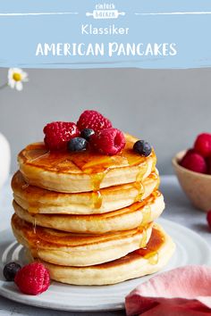 a stack of pancakes topped with berries and syrup