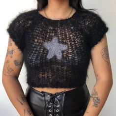 a woman with tattoos wearing a black top