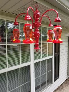 a red light fixture hanging from the side of a house