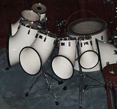 a group of white drums sitting on top of a blue floor next to a stool