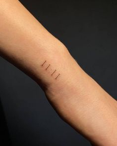 a person's arm with a small tattoo on it