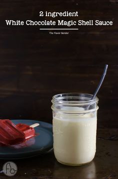 a glass jar filled with white chocolate magic shell sauce next to a plate full of red marshmallows