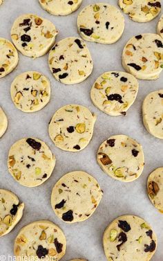 several cookies with nuts and raisins are on a baking sheet, ready to go into the oven