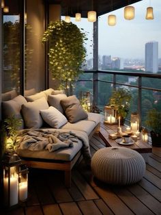 a couch sitting on top of a wooden floor next to a window filled with candles