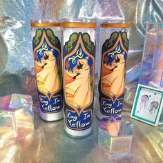 two disney princess tumblers sitting next to each other on a table with pictures and cards