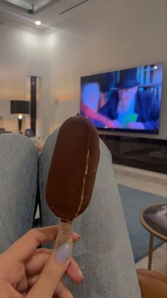 a person holding an ice cream cone in front of a tv