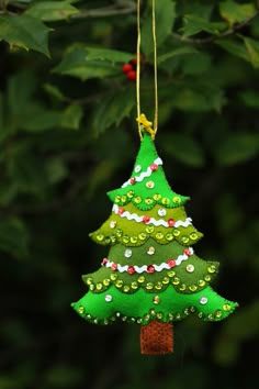 a green christmas tree ornament hanging from a tree