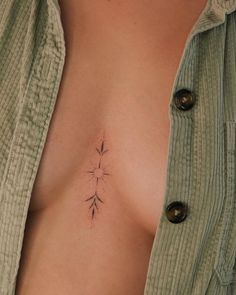 a woman's chest with a small tattoo on her left side and an arrow in the middle