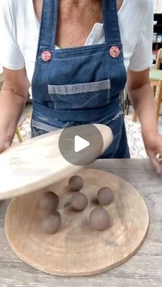 a woman in an apron is making chocolates