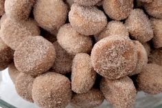 a glass bowl filled with sugared donuts