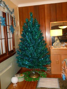 a blue christmas tree sitting on top of a wooden table