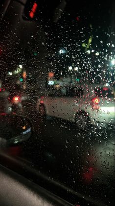 rain drops on the windshield of a car at night