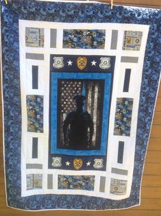 a blue and white quilt with a man in the center surrounded by stars, stripes and circles