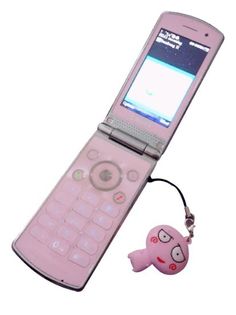 a pink cell phone with an emoticive keychain attached to it