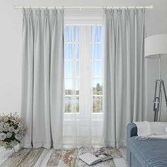 a living room with white walls and curtains