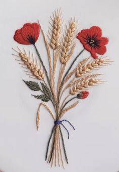 an embroidery project with red flowers and wheat