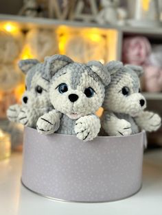 three small crocheted kittens sitting in a gray cup on top of a table