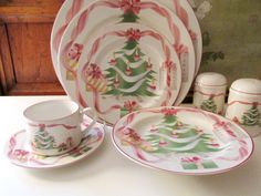 a white table topped with plates and cups filled with christmas decorations on it's sides