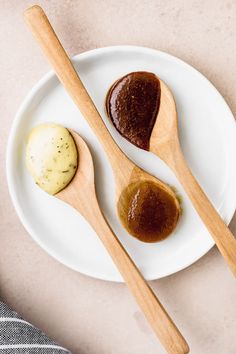 two wooden spoons sitting on top of a white plate