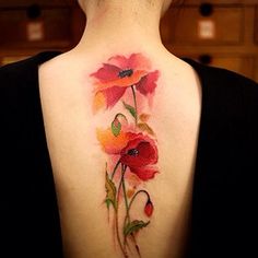 the back of a woman's neck with flowers painted on her upper and lower arm