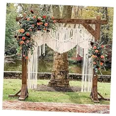 an outdoor wedding ceremony with macrami and orange flowers on the arbor, surrounded by greenery