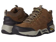 SKECHERS Arch Fit Recon - Romar - Men's Shoes : Khaki : Ensure comfort and style all day long wearing these SKECHERS Relaxed Fit Arch Fit Recon - Romar shoes featuring a waterproof upper and Goodyear Performance outsole. Waterproof leather and mesh upper. Textile lining. Removable SKECHERS Arch Fit insole system with podiatrist-certified arch support that reduces shock and increases weight dispersion. Relaxed Fit for a roomy comfort fit at toe and forefoot. Mid-top trail hiker design. Lace-up cl Brown Slip-resistant Walking Shoes For Hiking, Breathable Low-top Walking Boots, Breathable Low-top Leather Boots, Brown Slip-resistant Hiking Sneakers, Sporty Breathable Leather Boots, Sporty Leather Boots With Breathability, Rugged Waterproof Slip-resistant Boots For Sports, Brown Low-top Waterproof Boots With Cushioned Footbed, Breathable Leather Walking Boots