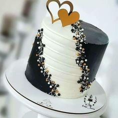 a black and white cake with gold hearts on top