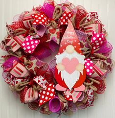 a wreath decorated with paper hearts and a santa clause on the front door for valentine's day