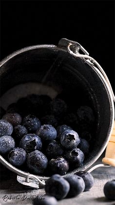 some blueberries are in a metal bucket