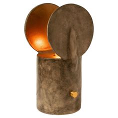 a table lamp that is made out of concrete and has an orange light in the middle