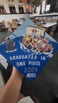 a blue graduation cap with images of animals on it and the words graduates in one piece