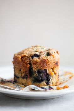 a blueberry muffin on a plate with a fork