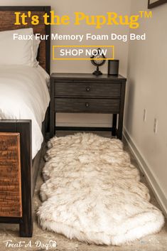 a bed with a furry rug on the floor next to a night stand and nightstand