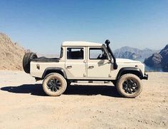 a white jeep parked on top of a mountain