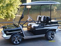 a black and white golf cart parked next to a river