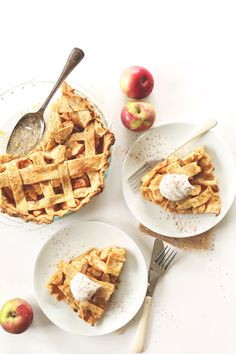 three plates with pies on them and apples in the background next to each other