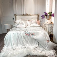 a bed with white sheets and pillows in a room