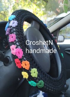 a steering wheel cover with crochet flowers on it