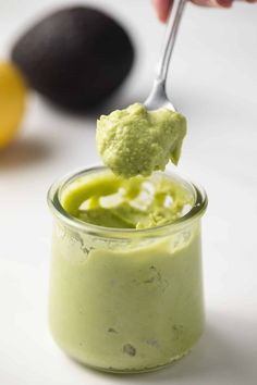 a spoon full of avocado dip in a jar