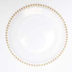 an empty white plate with gold beading on the rim and bottom, against a white background